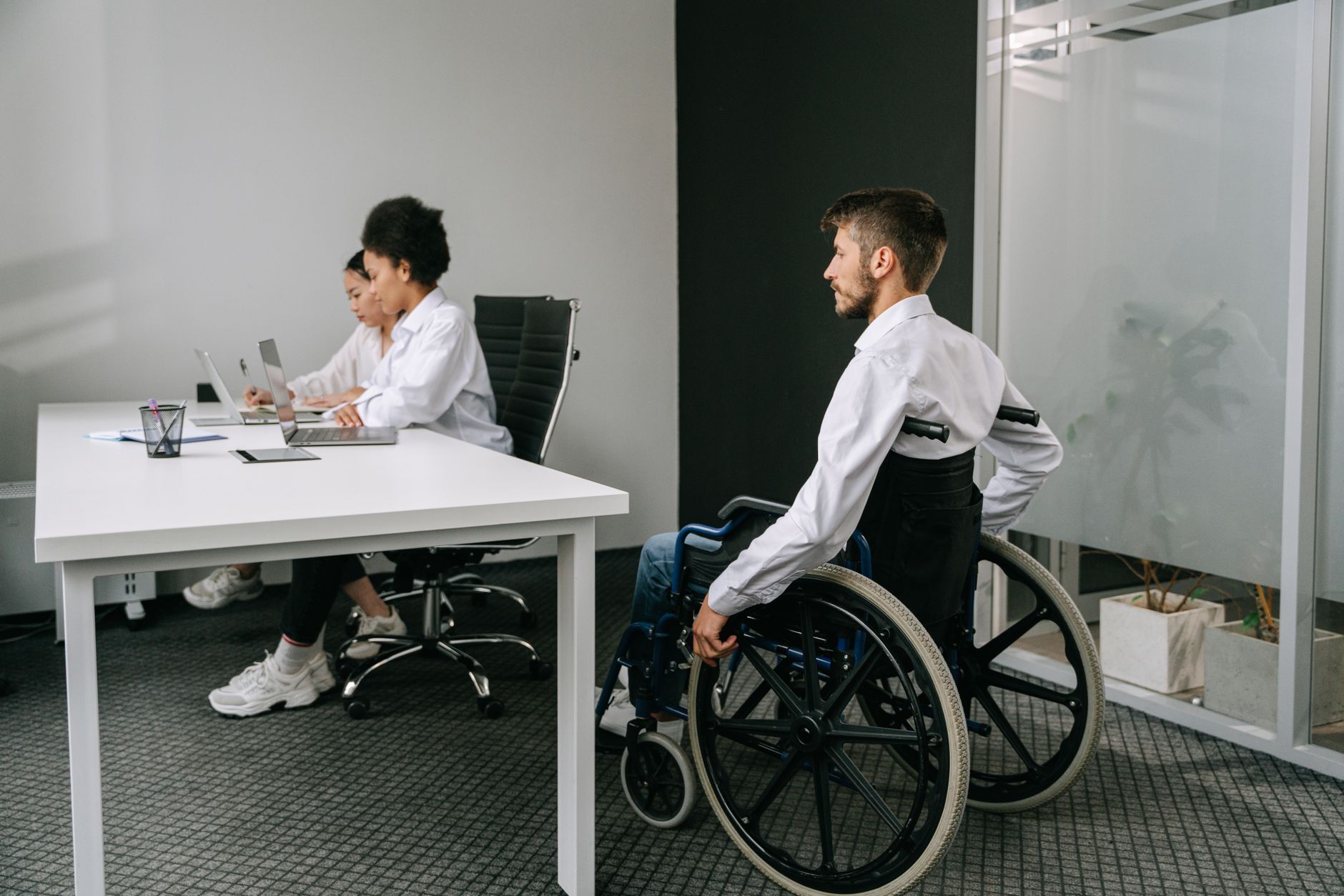 Diverse team in an office meeting, focusing on inclusive workplace and accessibility.
