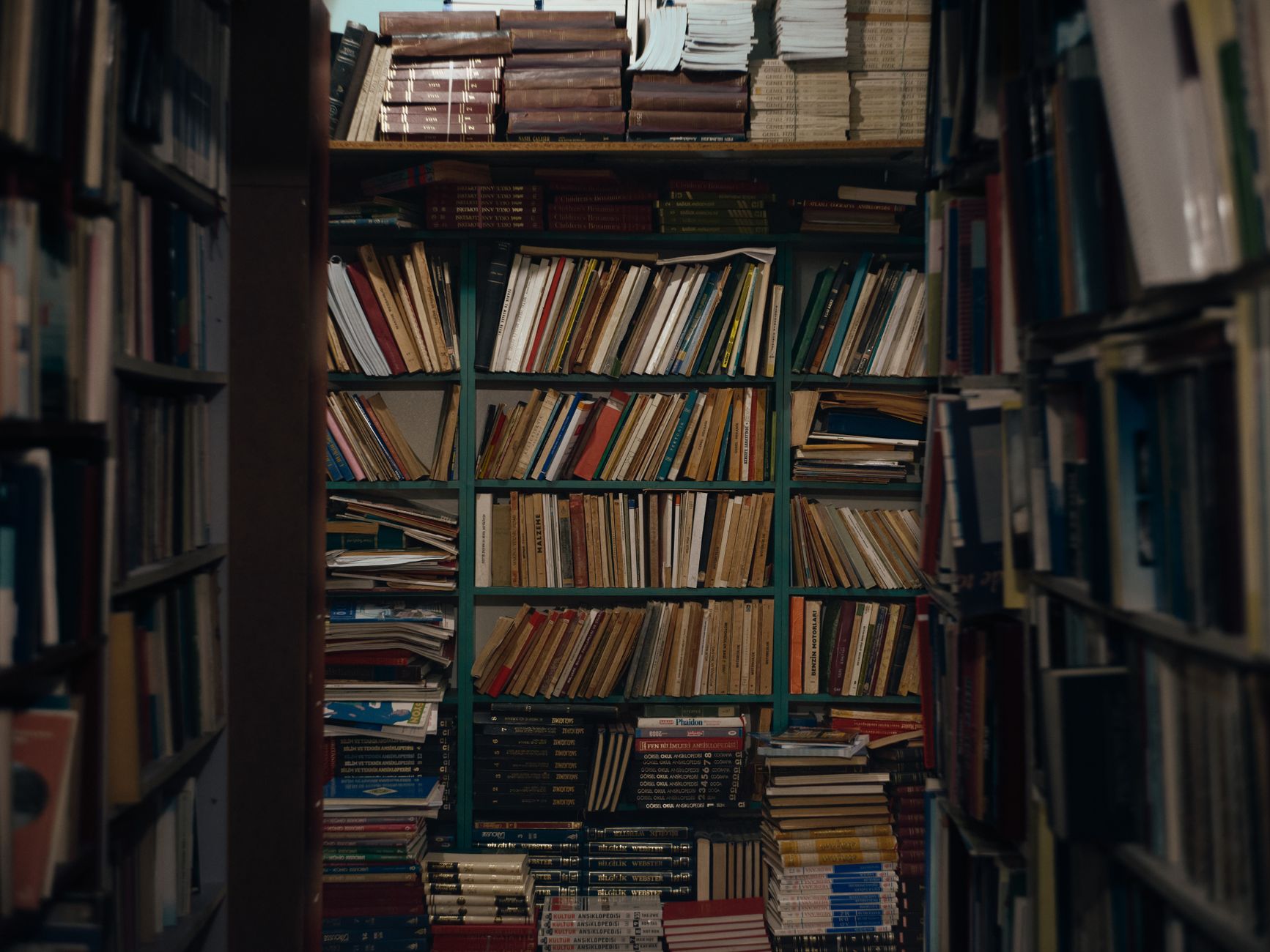 A view of overflowing bookshelves in an antique bookstore in Antalya, Turkey, showcasing a wide range of literature.